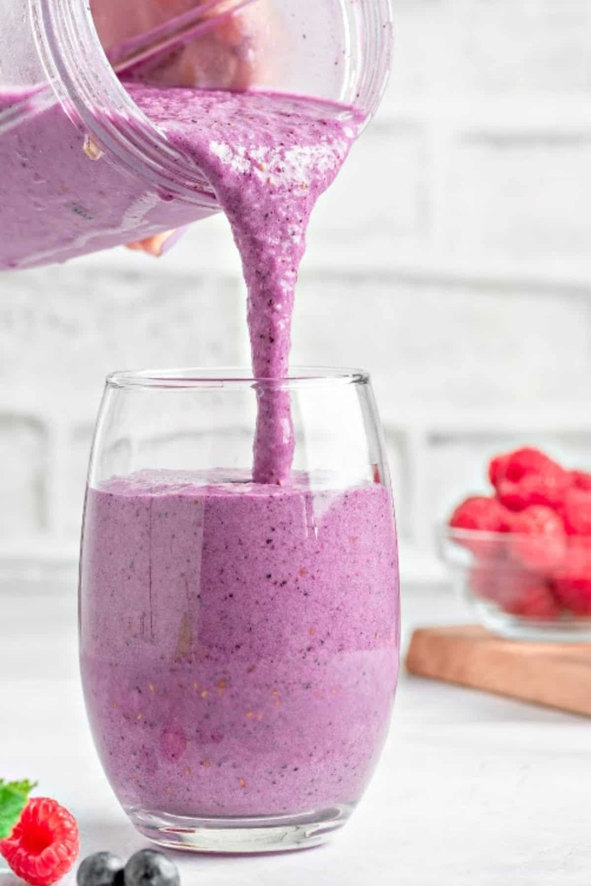 keto berry smoothie in a blend cup being poured into a glass