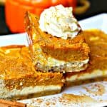 close-up of three keto pumpkin pie cheesecake bars stacked on top of each other