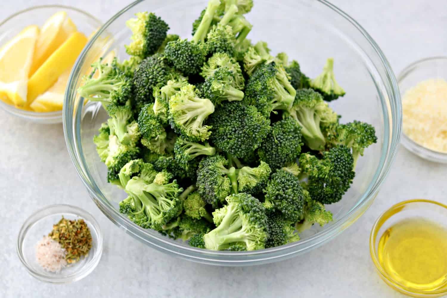 One bowl of broccoli with olive oil, lemon, parmesan and seasonings