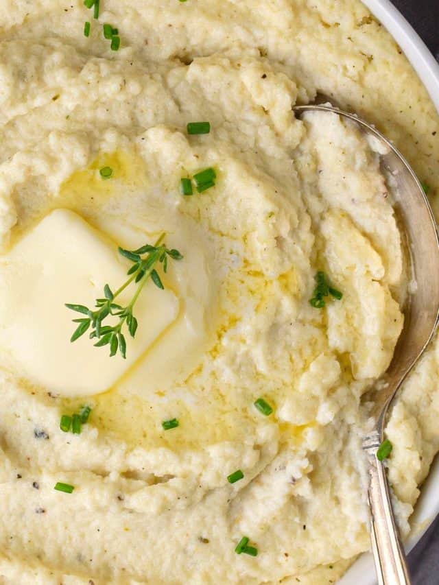 a close-up of a bowl of roasted cauliflower mash in a bowl with herbs and butter
