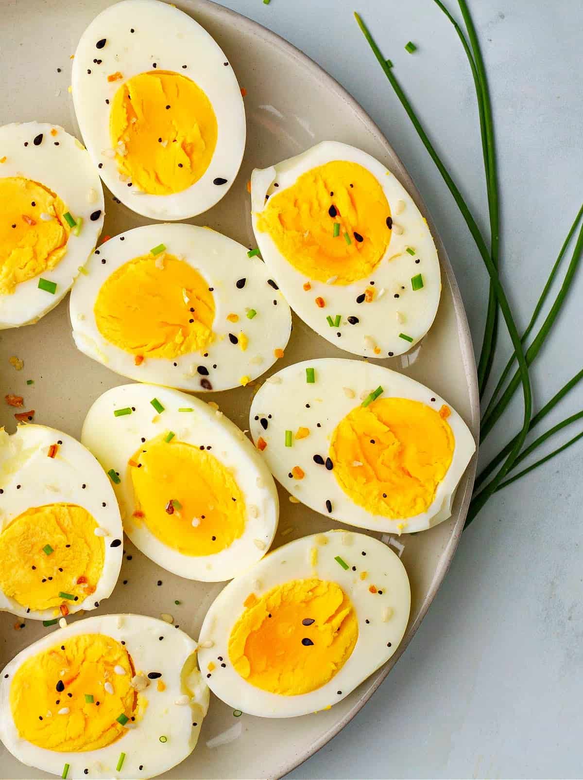 a close-up of air fryer eggs on a plate with chives and everything bagel seasoning