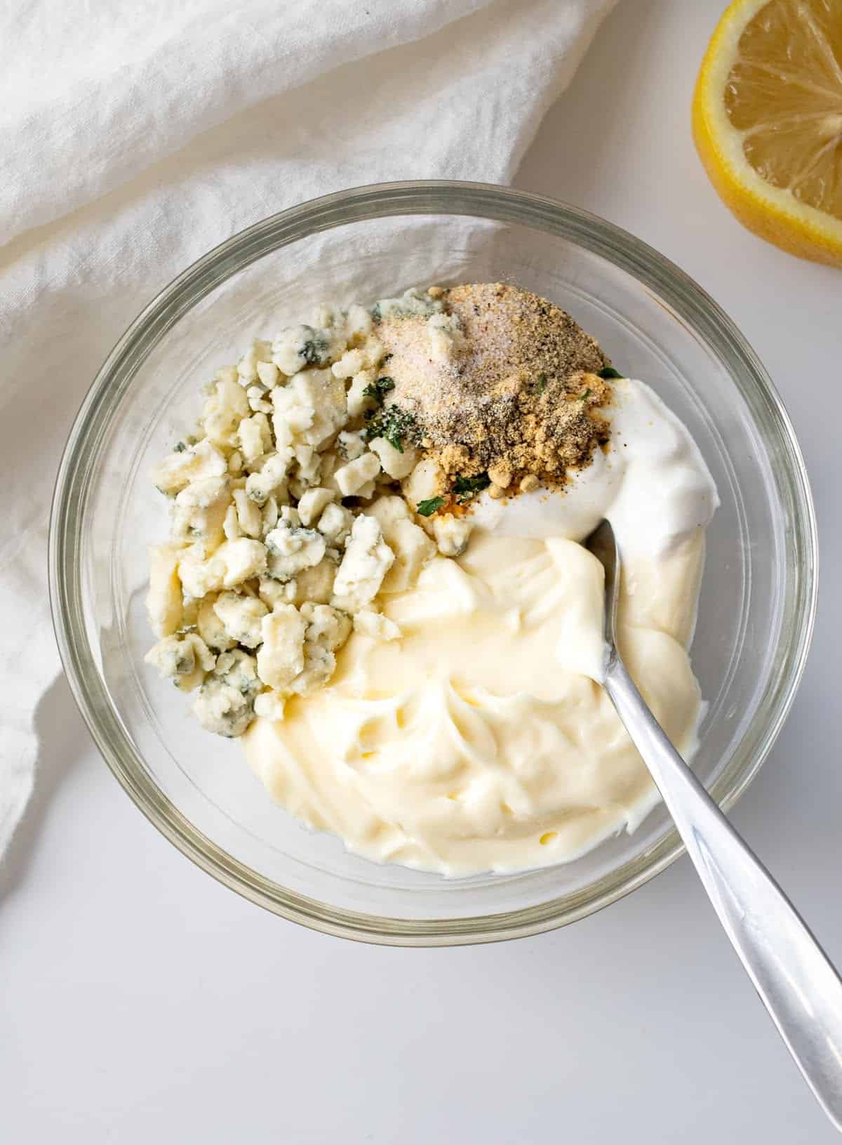 A bowl filled with homemade keto blue cheese dressing ingredients