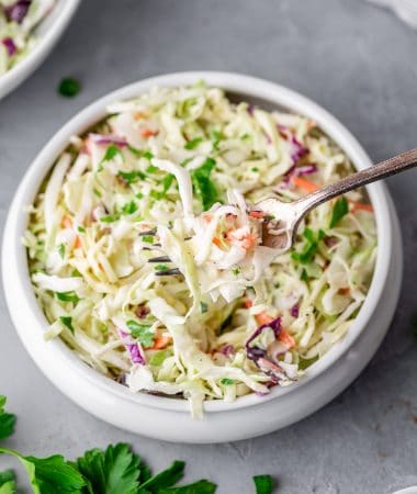 a bowl of keto coleslaw with a fork in it
