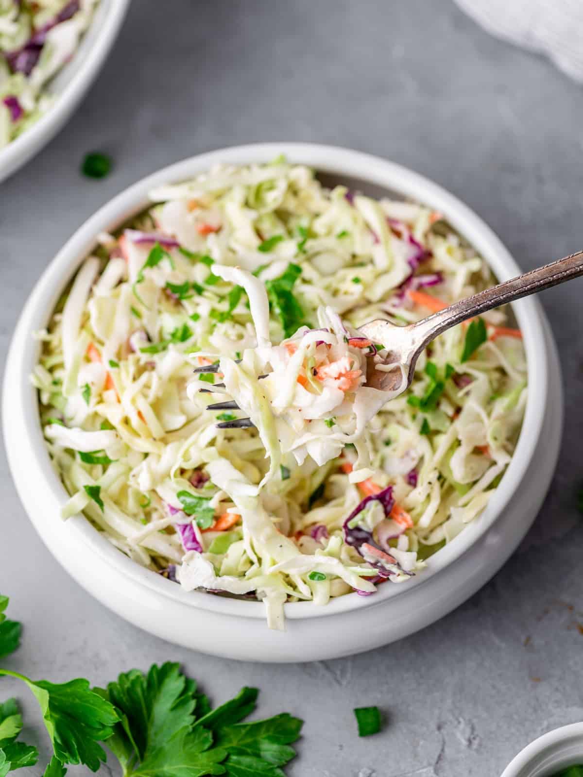 a bowl of keto coleslaw with a fork in it