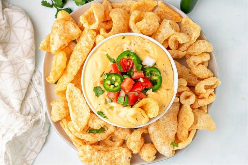 close up of keto queso in a bowl with pork rinds