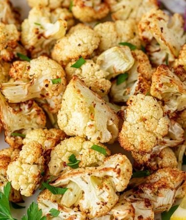 roasted cauliflower on a plate with lemon slices