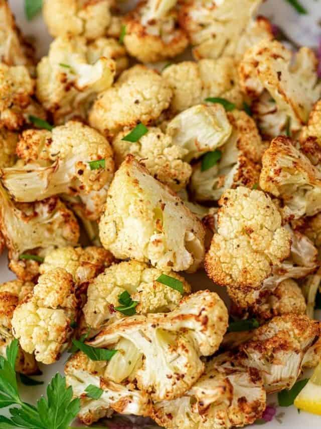 roasted cauliflower on a plate with lemon slices