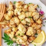 air fryer roasted cauliflower on a plate with lemon and parsley