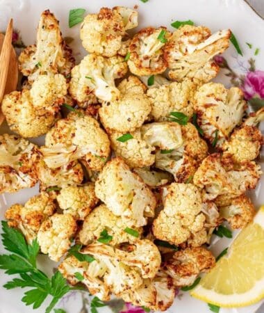 air fryer roasted cauliflower on a plate with lemon and parsley
