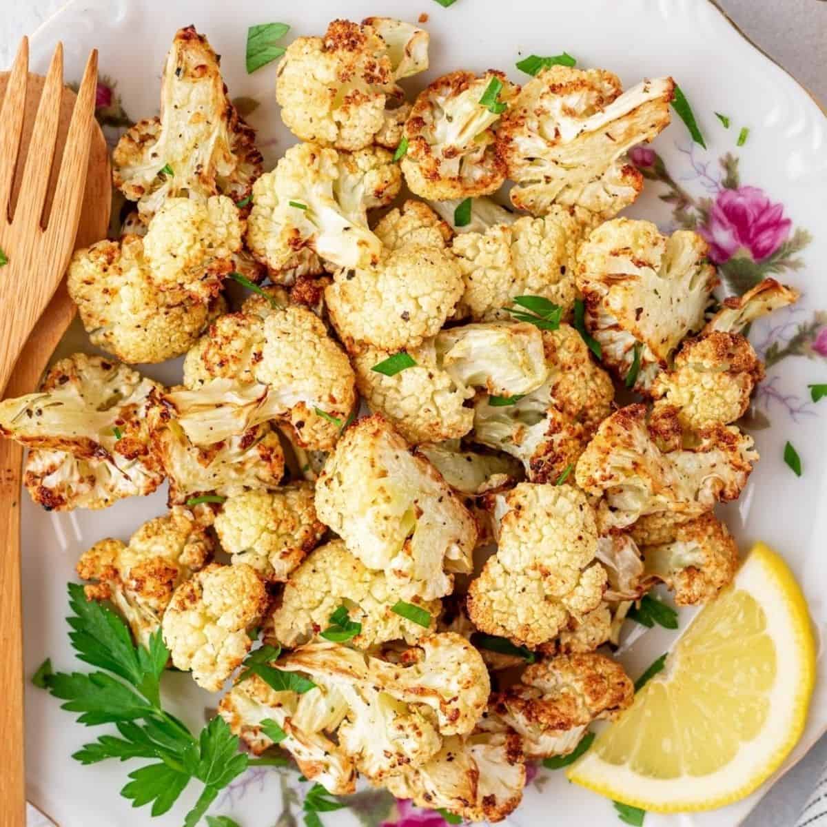 air fryer roasted cauliflower on a plate with lemon and parsley