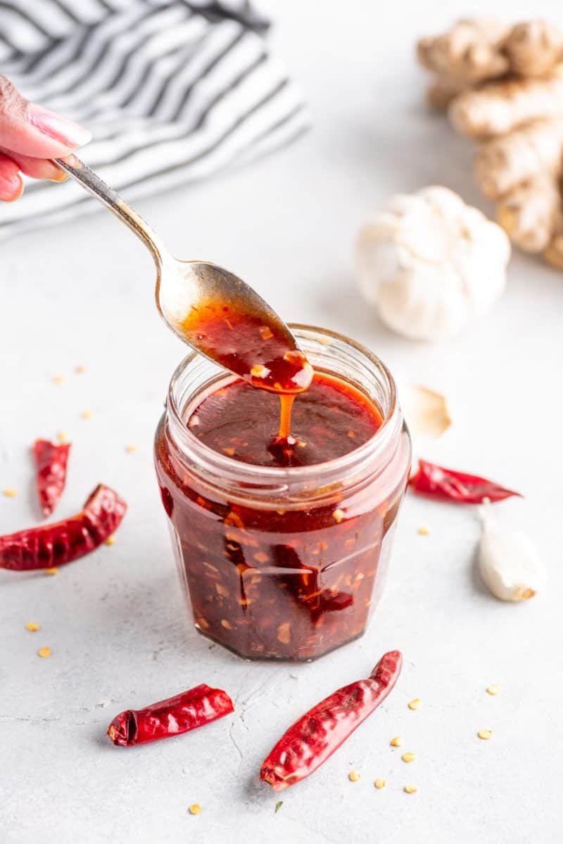 keto sweet chili sauce in a jar with chili peppers and garlic
