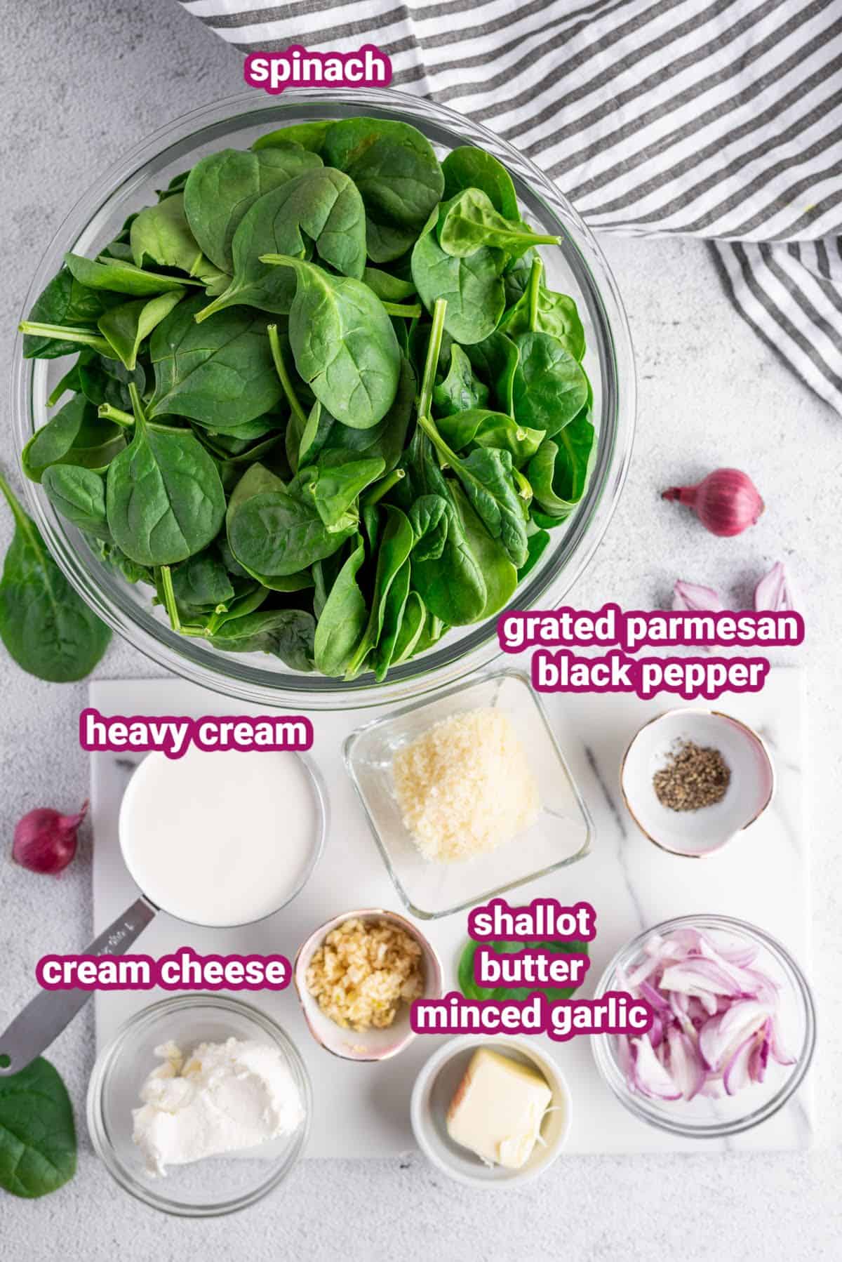 a photo of the ingredients for this keto creamed spinach recipe like spinach, heavy cream, grated parmesan, cream cheese, shallots, butter, minced, small pieces of garlic, and black pepper.