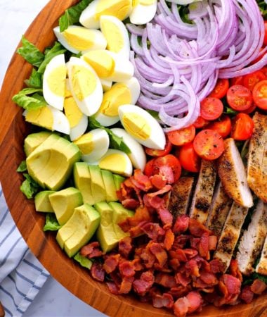 keto chicken Cobb salad in a bowl with crisp bacon, sliced chicken, and fresh vegetables