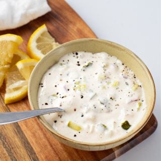 a close-up photo of a bowl of tartar sauce with lemon slices