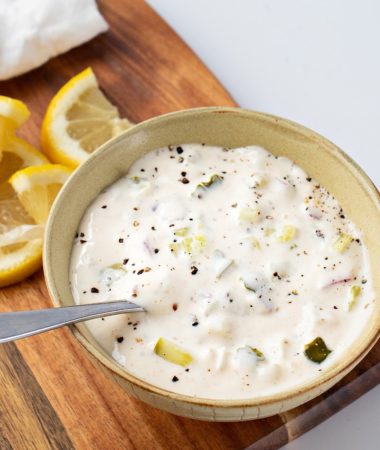 a close-up photo of a bowl of tartar sauce with lemon slices