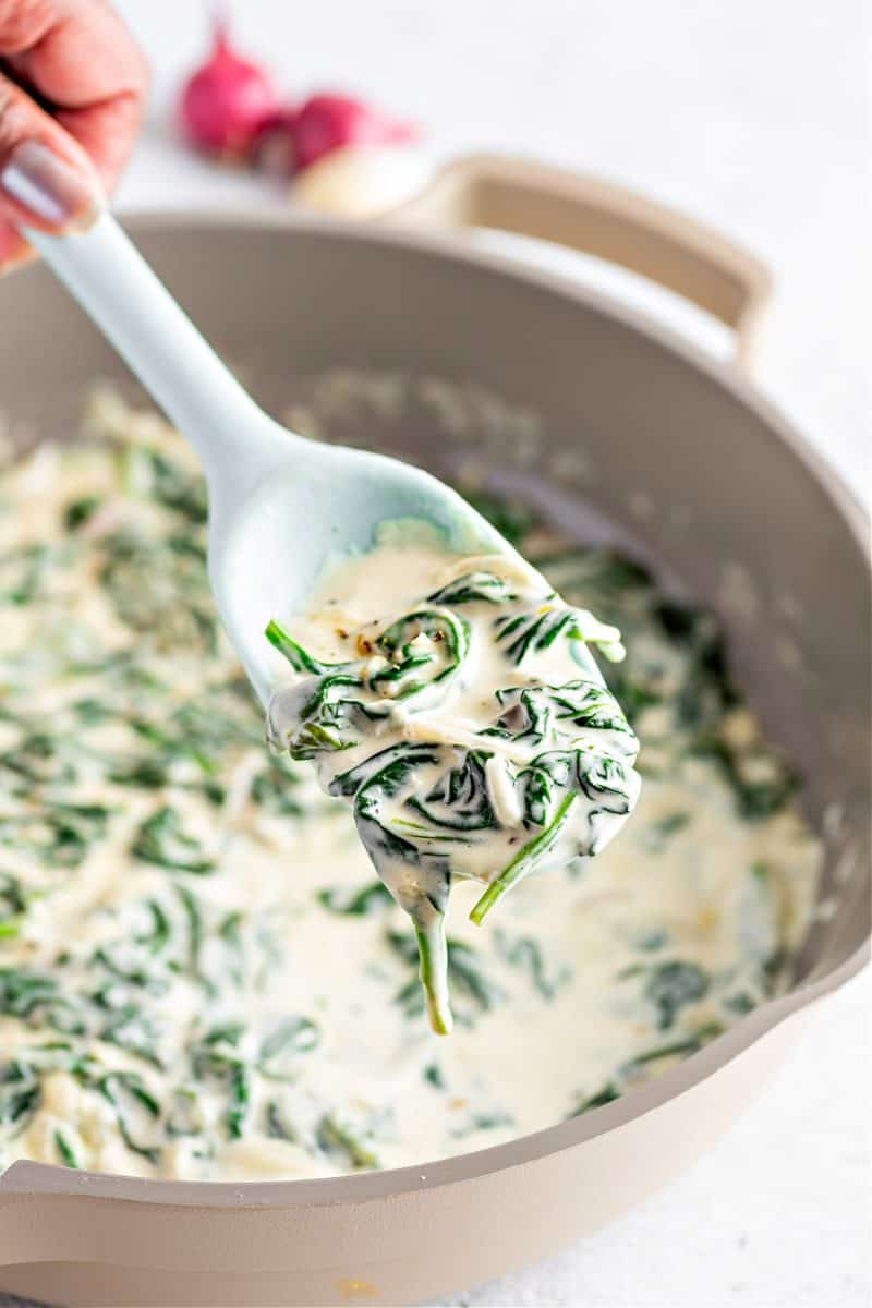 creamed spinach in a pot about to be served