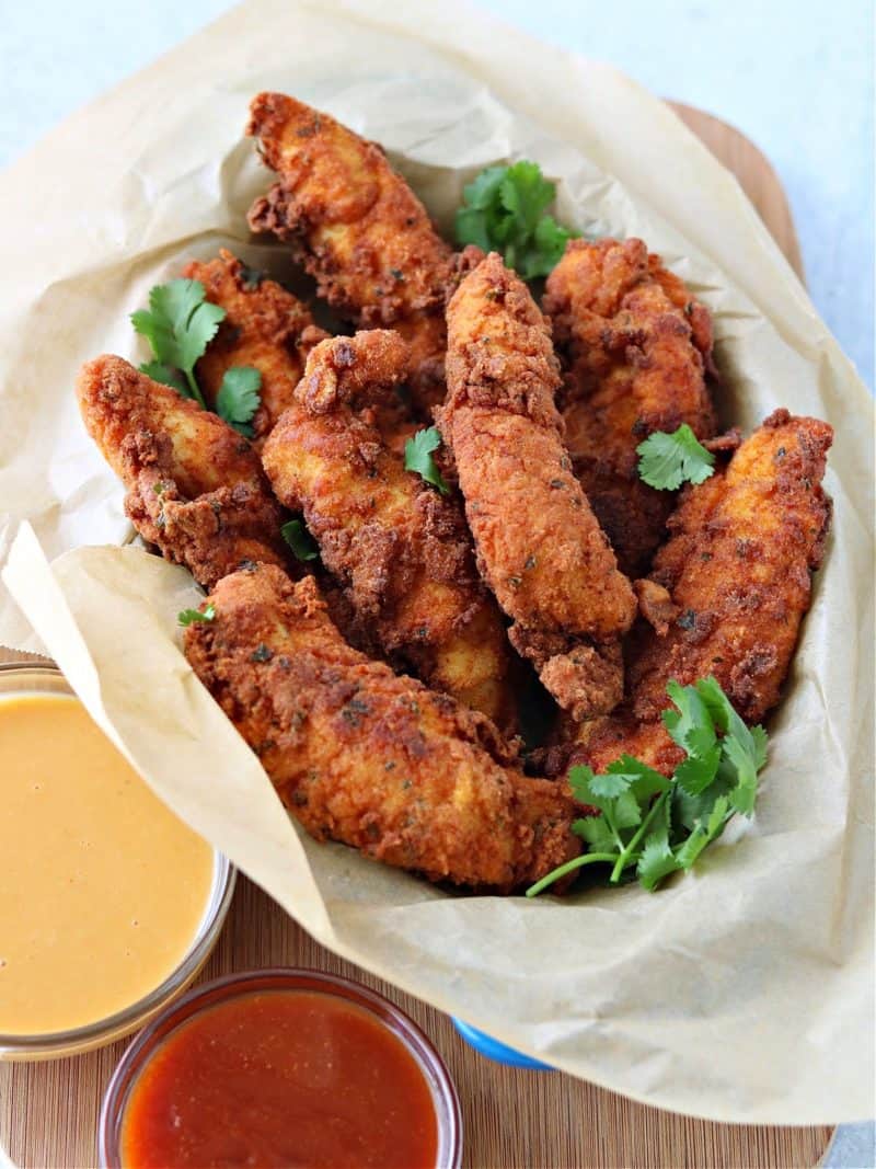 keto chicken tenders in a small pan with keto bbq sauce and copycat sugar-free chick-fil-a sauce