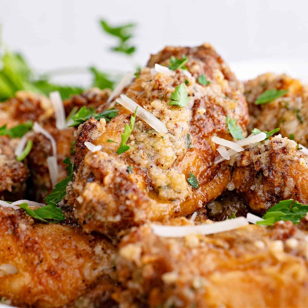 a close-up photo of a garlic parmesan wing on a plate