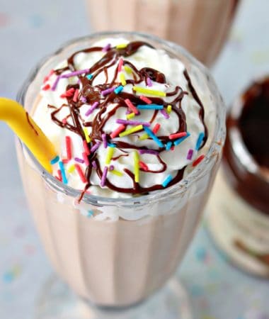 an overhead view of keto nutella frosty in a glass mug with keto whipped cream and sprinkles on top