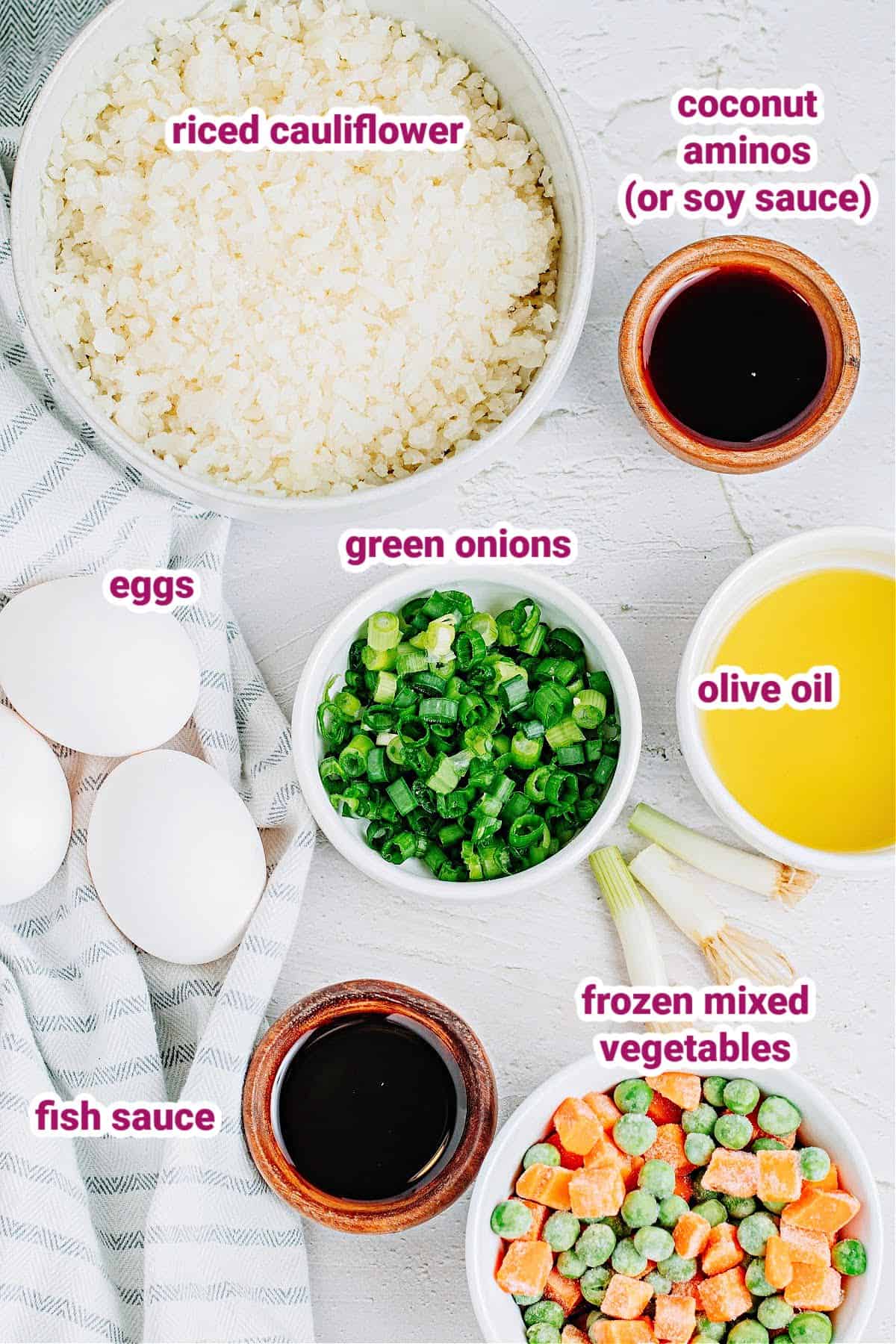 ingredients needed to make vegetable cauliflower fried rice with like cauliflower rice, green onions, eggs, coconut aminos, olive oil, frozen mixed vegetables, and fish sauce. 