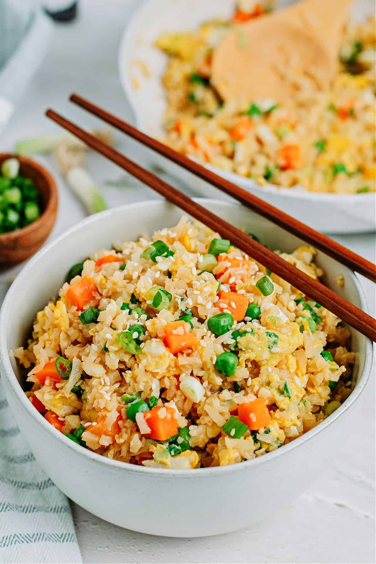 keto cauliflower fried rice in a bowl and a pan
