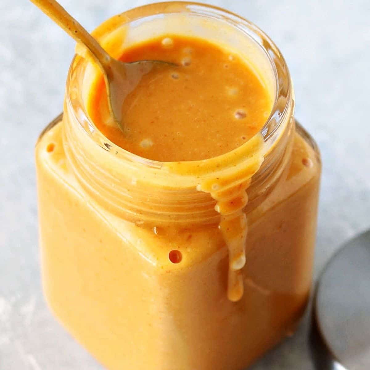 easy chick-fil-a sauce recipe in a glass jar with a spoon