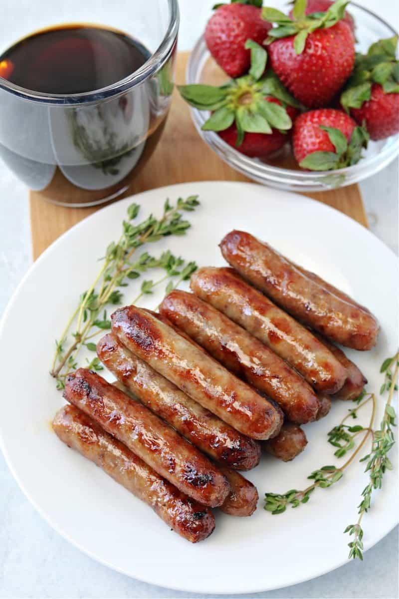 air fryer breakfast sausage links on a plate with coffee and strawberries