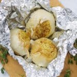 three garlic bulbs roasted in foil with thyme