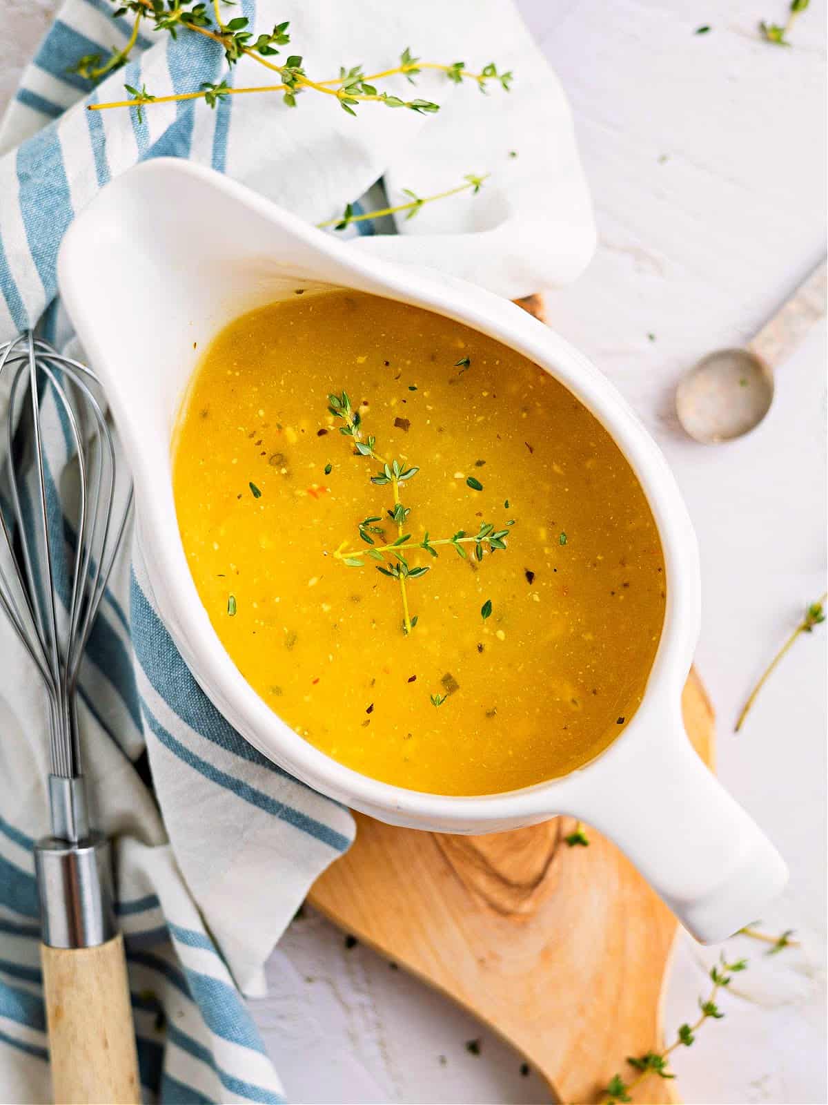 keto gravy in a sauce boat topped with fresh thyme sprigs