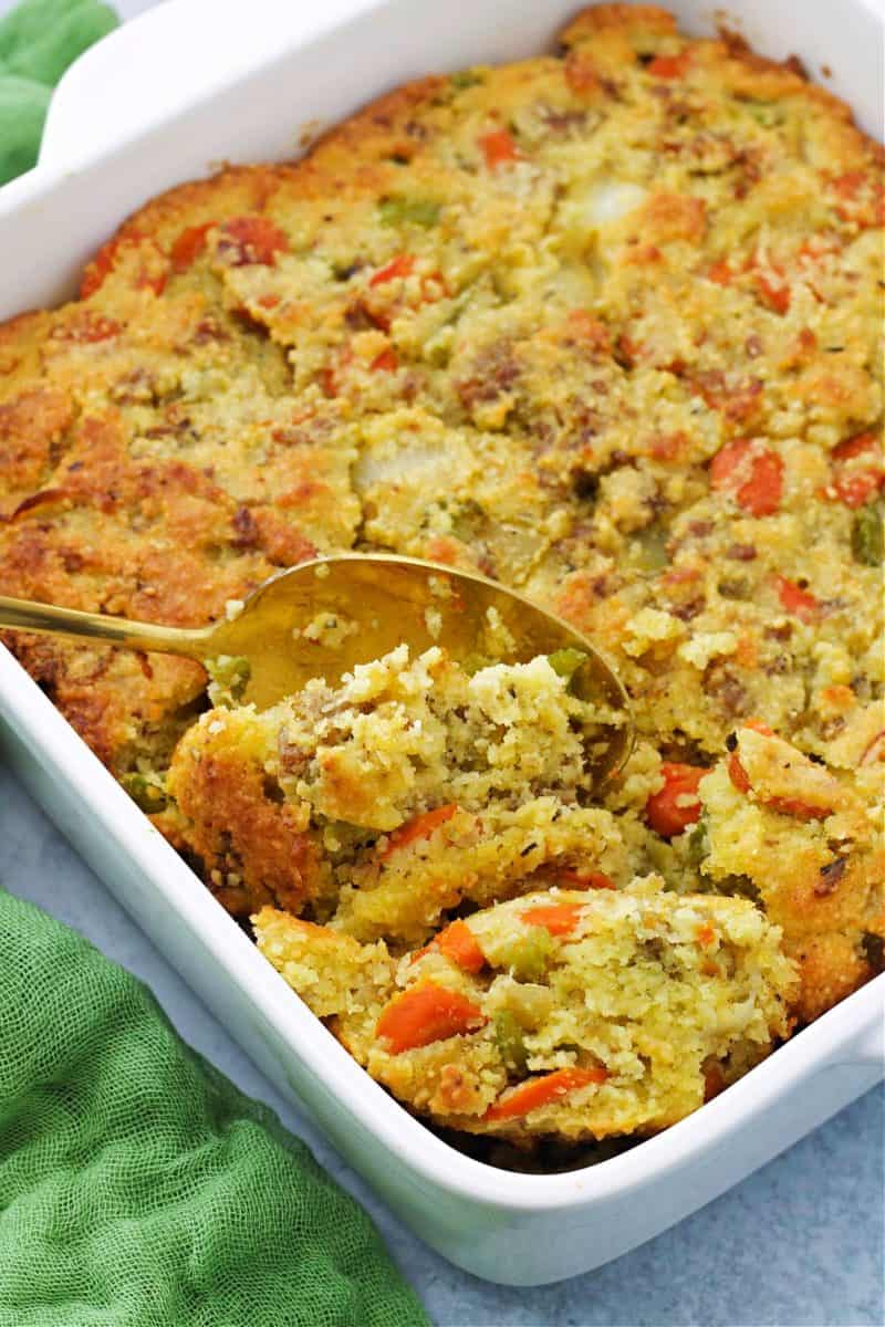 keto cornbread stuffing in a white baking dish with a spoon
