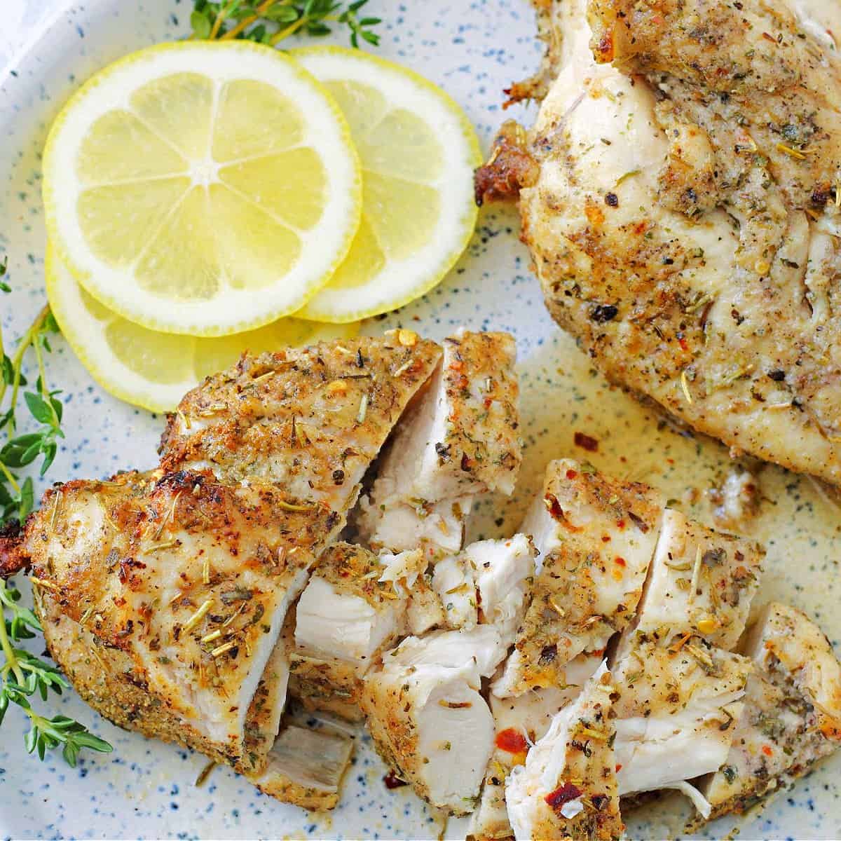 air fried chicken breasts on a plate with a squeeze of lemon