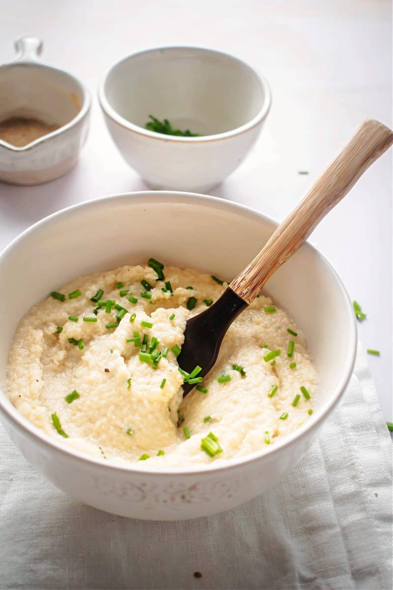 almond flour keto grits in a bowl, topped with sliced green onions.