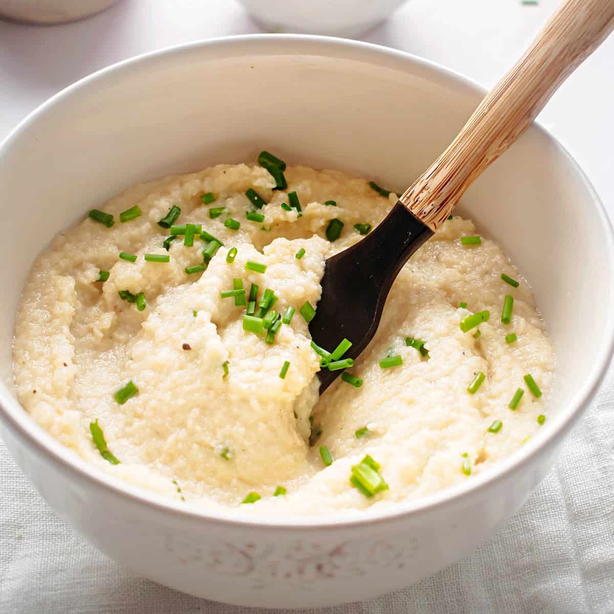 keto grits in a bowl with chives on top