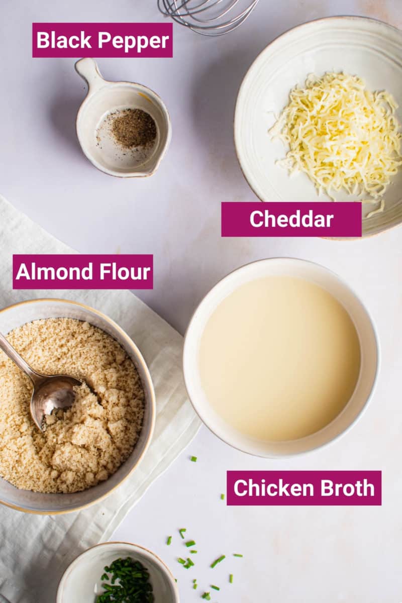 ingredients needed to make keto grits: almond flour, cheese, chicken broth, and black pepper in separate bowls
