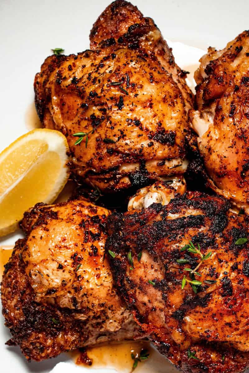 air fryer chicken thighs on a plate with a lemon wedge