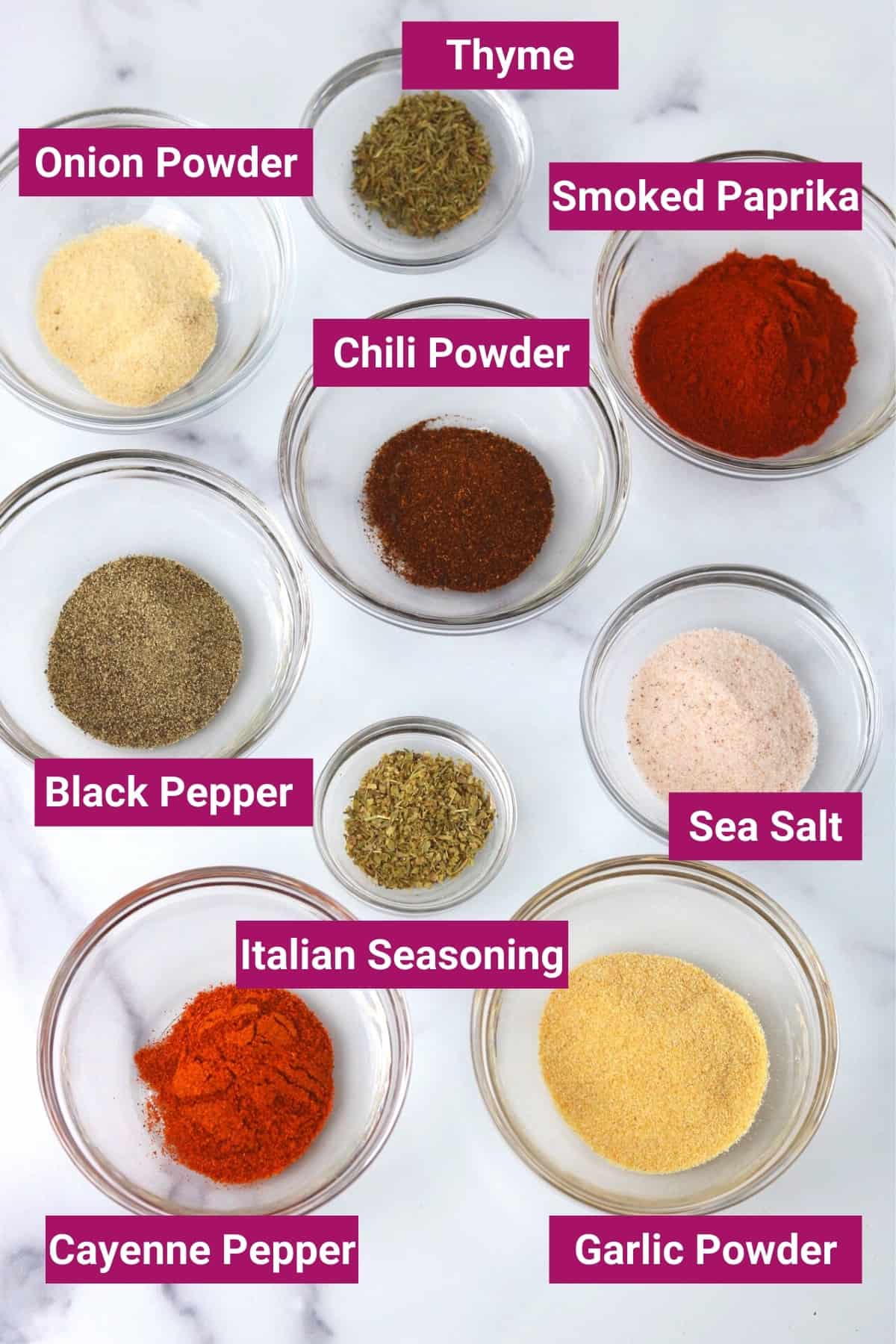 photo of the spices used to make homemade chicken dry rub: black pepper, Italian seasoning, sea salt, chili powder, smoked paprika, garlic powder, thyme, and cayenne pepper.
