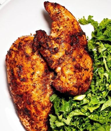 close-up of two dry rub chicken breasts on a plate