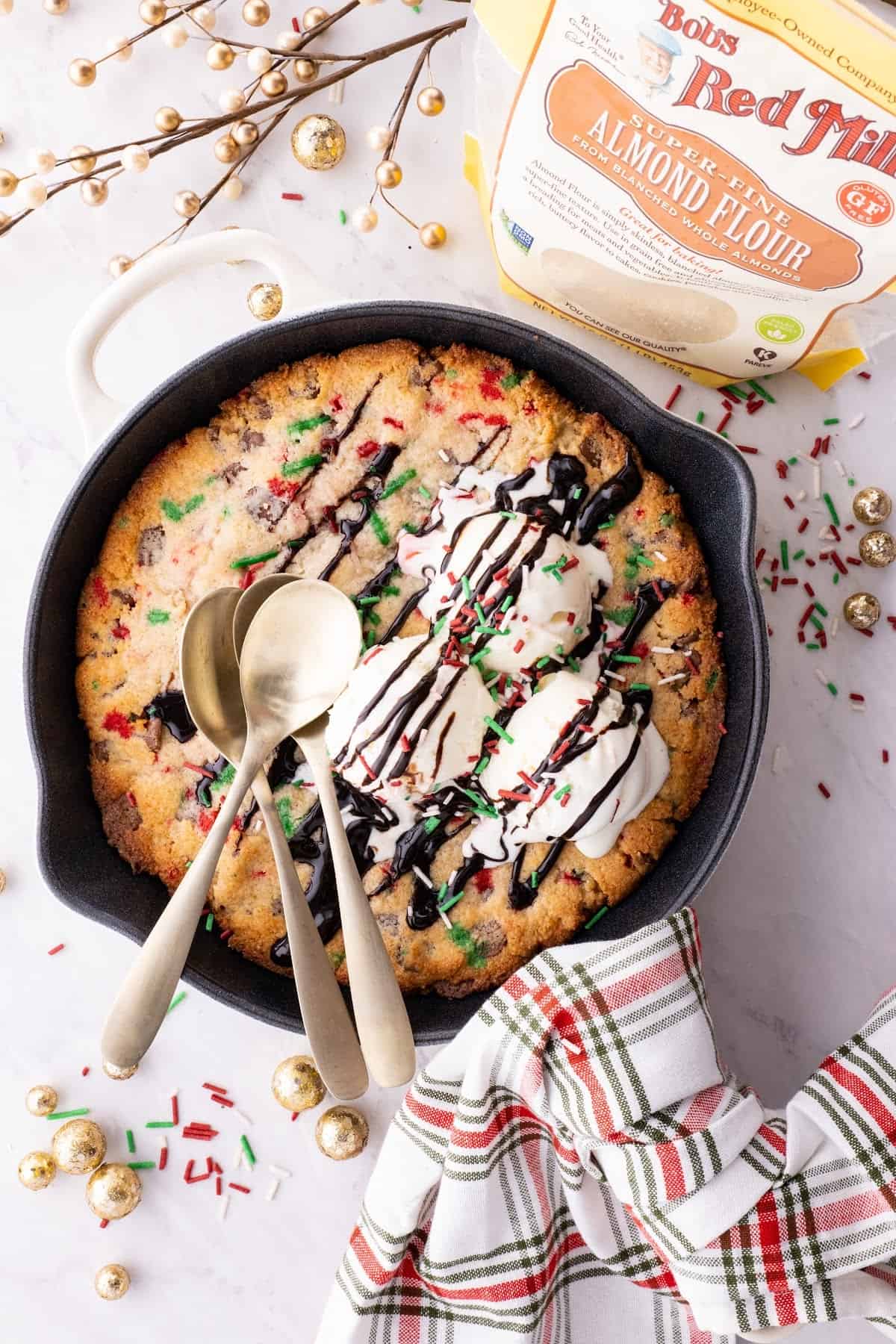 almond flour chocolate chip skillet cookie in a cast iron skillet topped with keto vanilla ice cream with bob's red mill almond flour