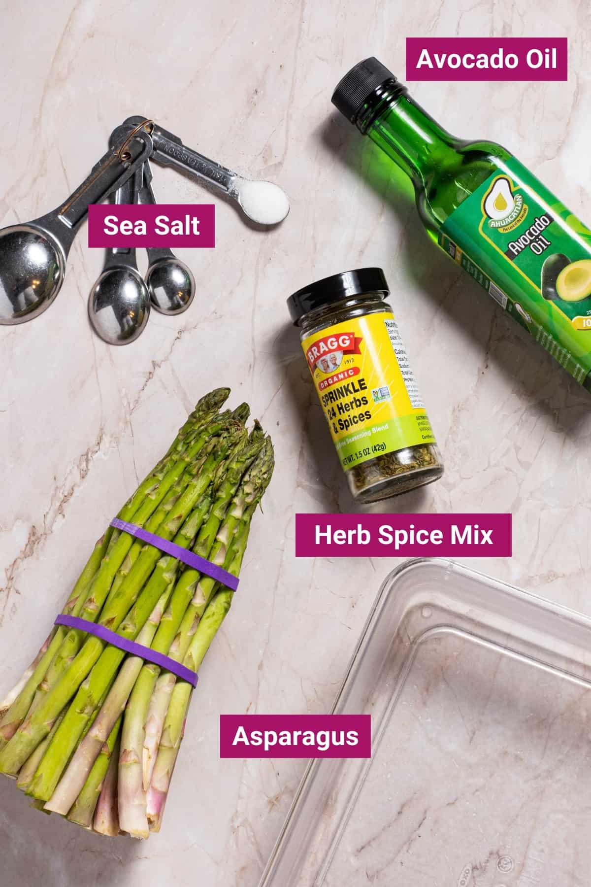 ingredients needed to make air fryer asparagus like raw asparagus, salt, avocado oil, herb seasoning blend, and a shallow dish.