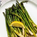 ninja foodi air fryer asparagus on a plate with a slice of lemon