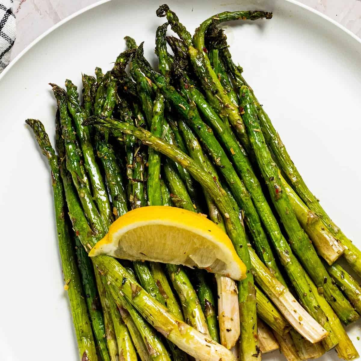 ninja foodi air fryer asparagus on a plate with a slice of lemon