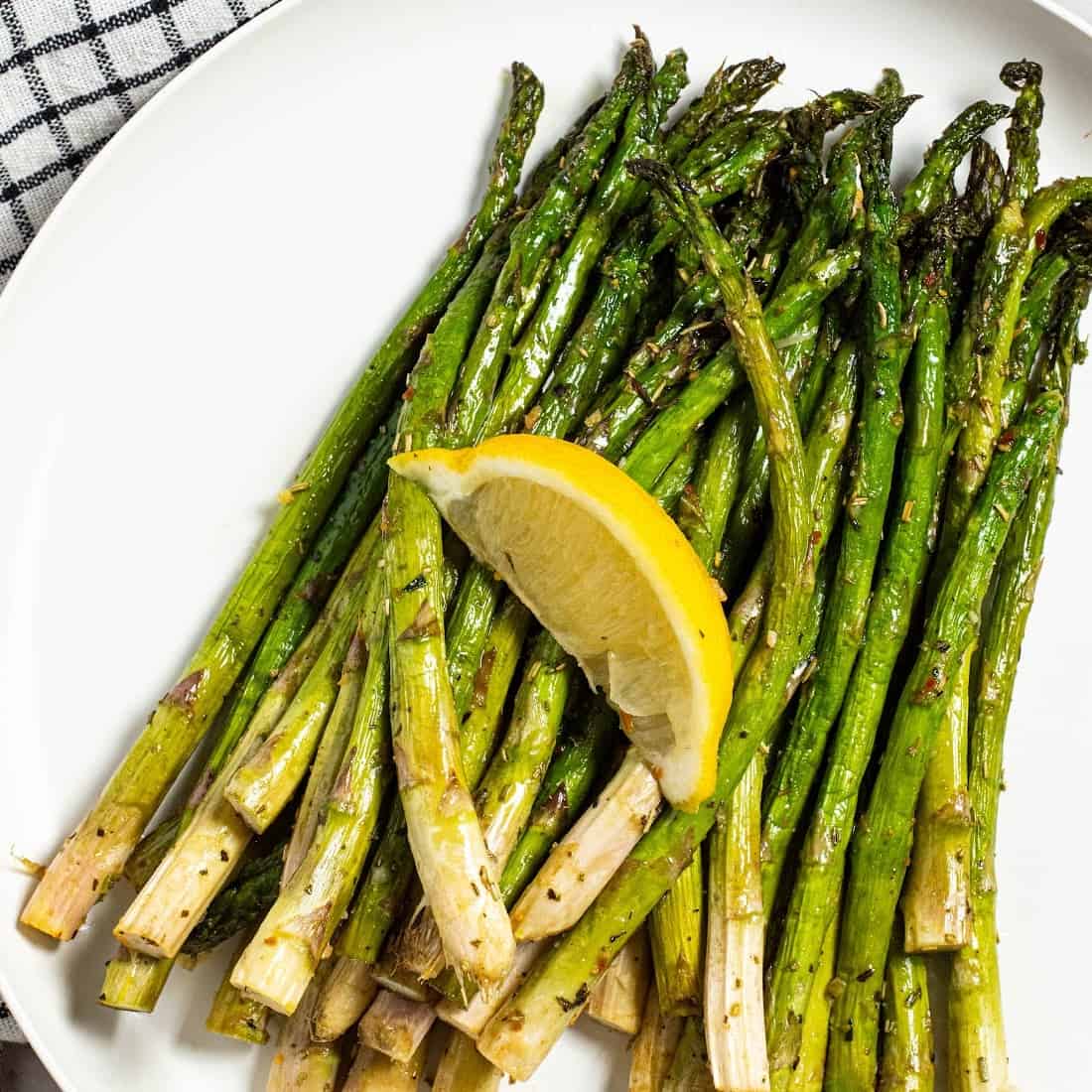 air fryer asparagus on a plate with a lemon slice
