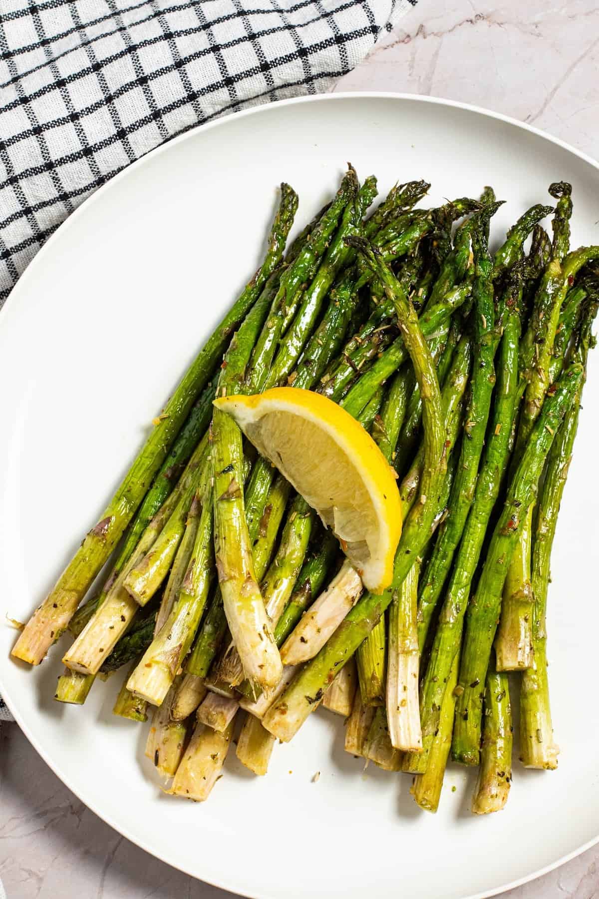 Air Fryer Asparagus on a plate with a lemon slice