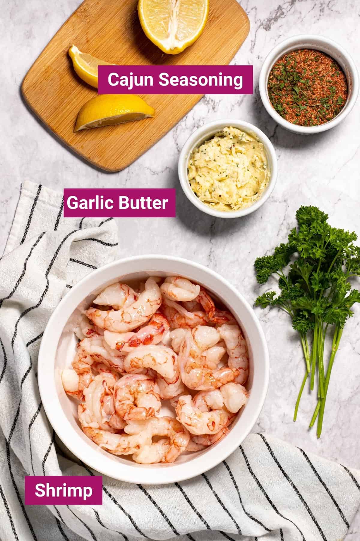cajun seasoning, lemon, garlic butter, and shrimp in separate bowls