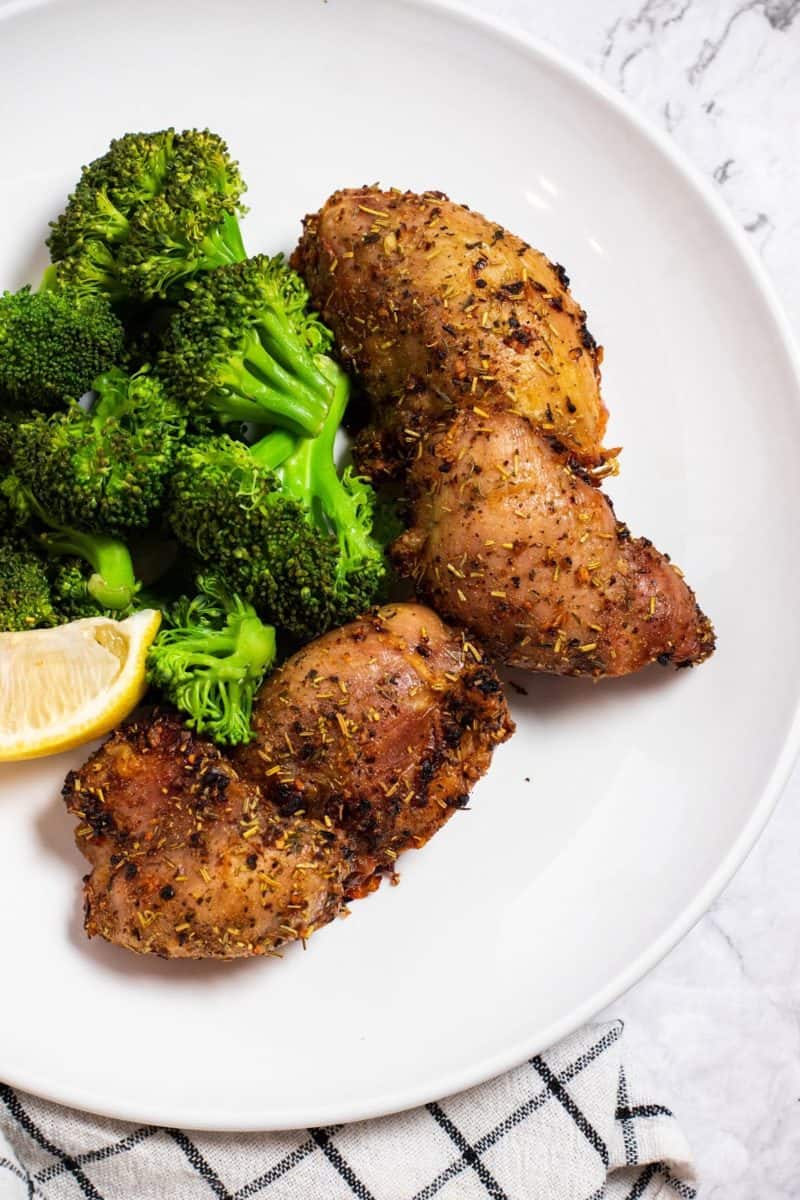 boneless air fryer chicken thighs on a plate with broccoli