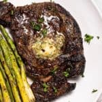 close up of Ninja Foodi air fryer steak on a plate with air fryer asparagus