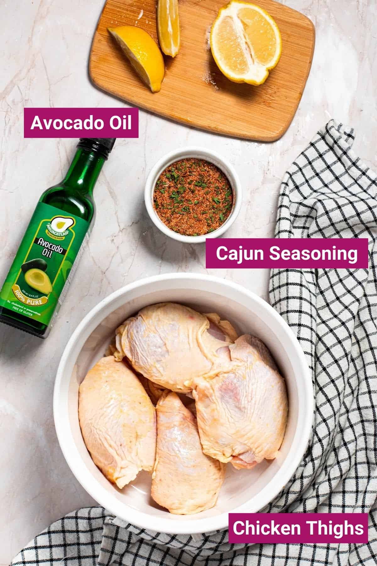 chicken thighs, avocado oil, cajun seasoning, and lemon in separate bowls