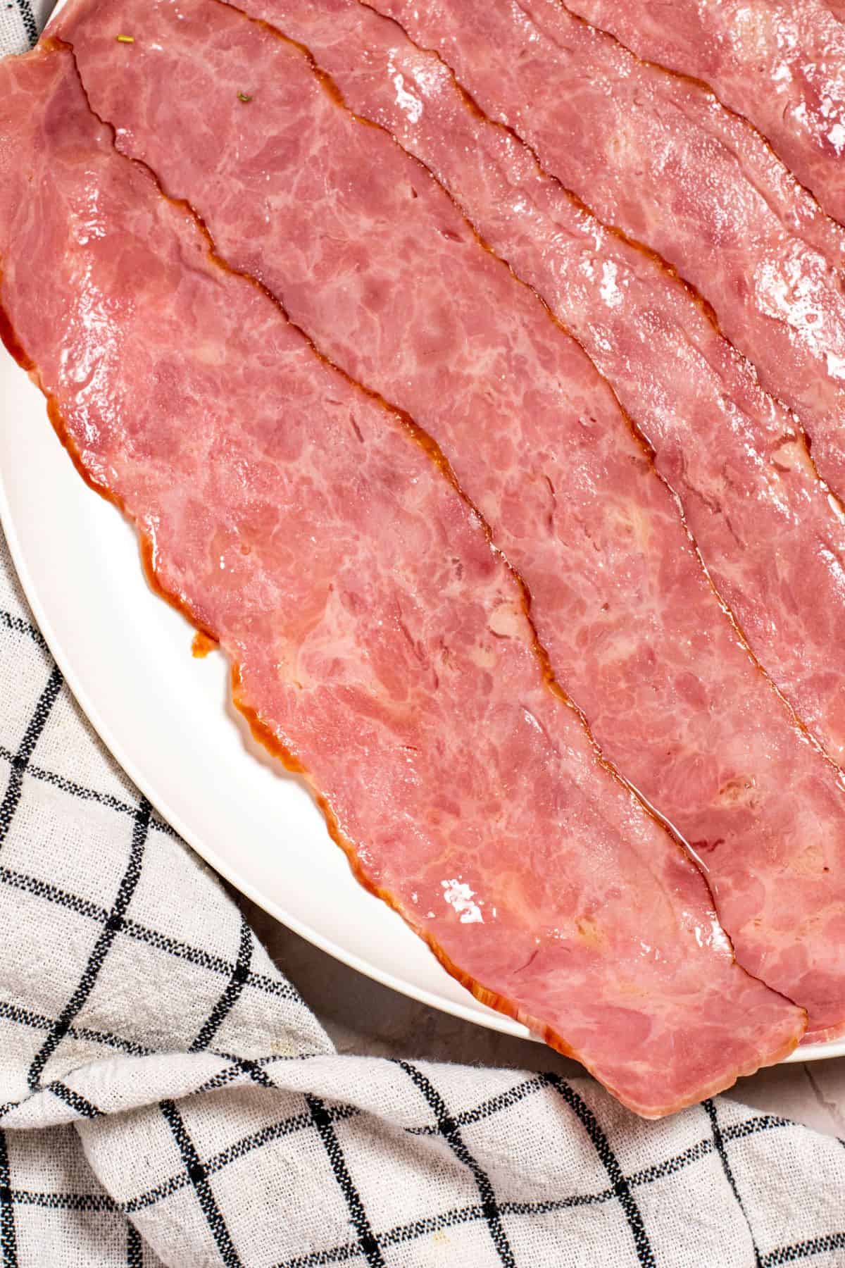 cooked bacons on a white plate
