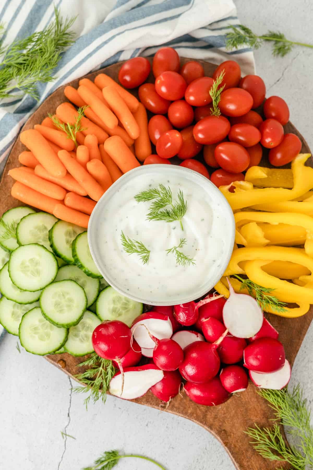 Greek Yogurt Ranch Dip surrounded by fresh veggies on a wooden board