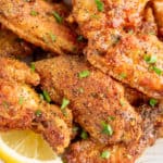 crispy lemon pepper wings topped with parsley sprigs on a plate